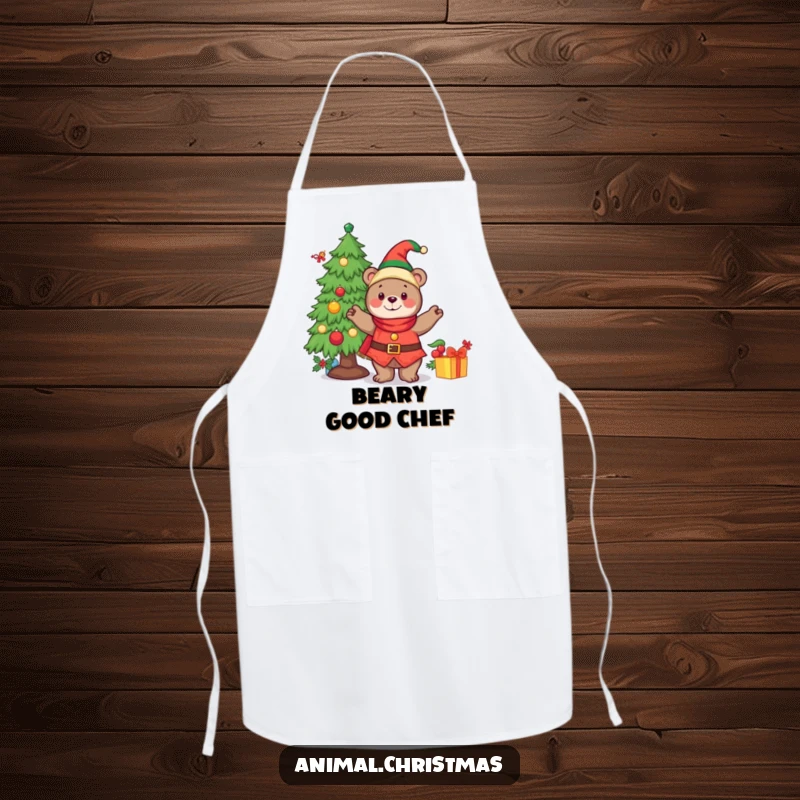 Funny apron with a cheerful bear dressed as an elf, decorating a Christmas tree while holding baking supplies.