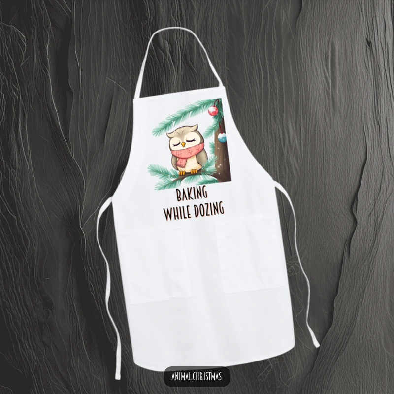 Funny Christmas apron showing a sleepy owl wearing a knitted scarf, tucked inside a frosted pine tree, ready for kitchen duties.