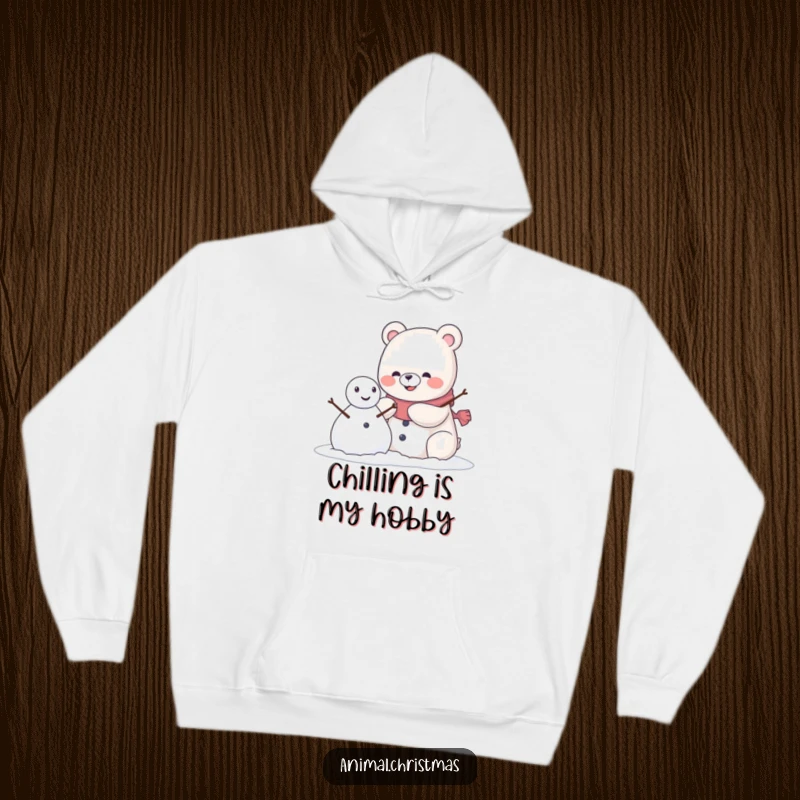 Funny kawaii bear with a pleased grin building a snowman, featured on a soft and warm hoodie.