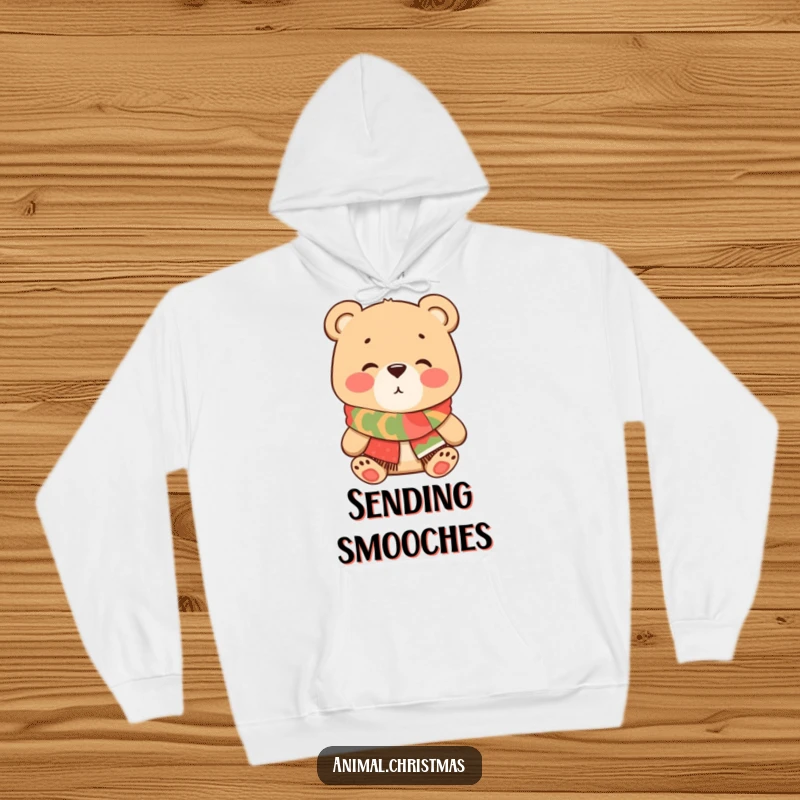 Funny Bear Kiss Hoodie, a charming cartoon bear wearing a festive scarf blows a kiss, offering warmth and affectionate humor for cozy wear.
